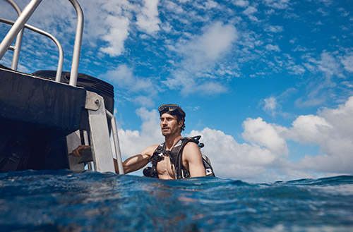 A man swimming along side the scuba boat at Kokomo Island Fiji.