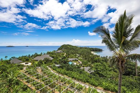 A view of Kokomo Island Fiji from the island’s peak, overlooking the small farm towards the residences and villas nestled amongst the island’s lush greenery.