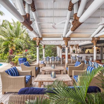 Kokocabana pool area at Kokomo Island Fiji, with an infinity pool, tropical plants, and an open-air lounge in the background.