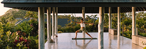 Guests in a yoga session on a floating pontoon at Kokomo Private Island Fiji.